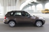 Driving 2013 BMW X5 xDrive50i in Sparkling Bronze Metallic from a right side view